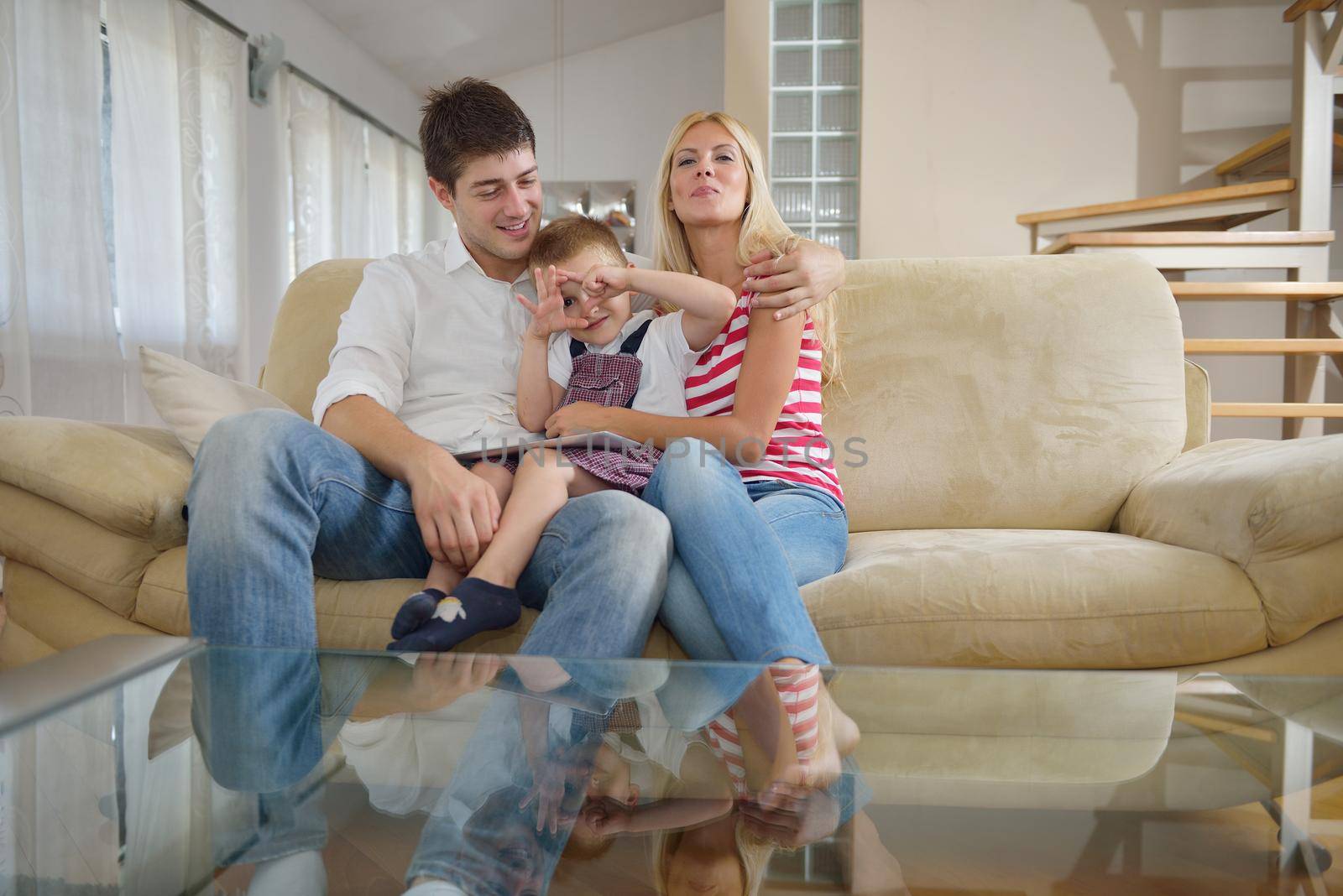 happy young family using tablet computer at modern  home for playing games and education