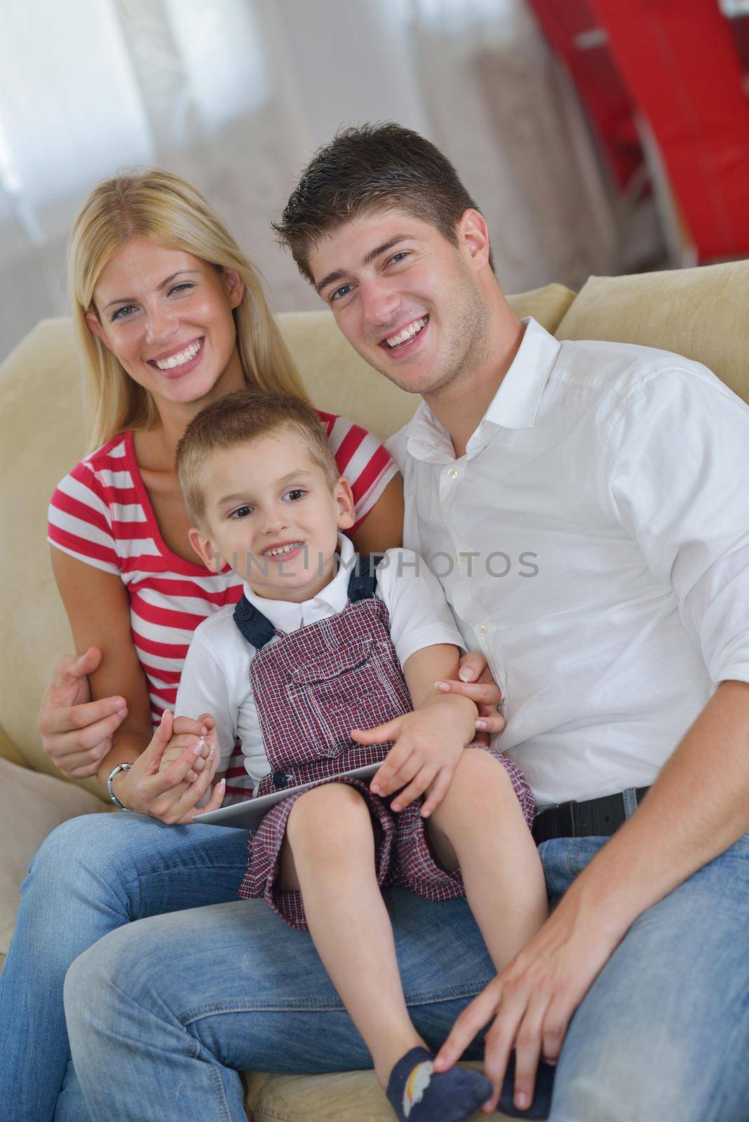 happy young family with kids in bright modern living room have fun and looking big flat lcd tv