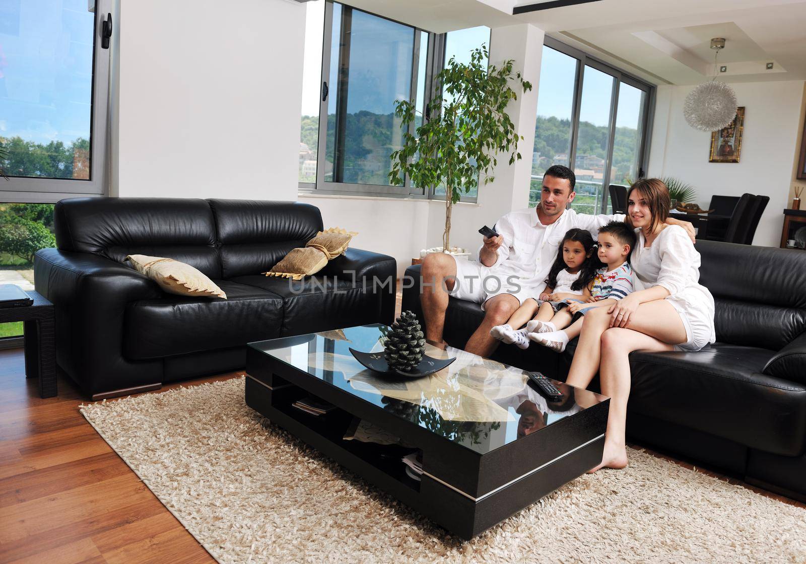 happy young family wathching flat tv at modern home indoor