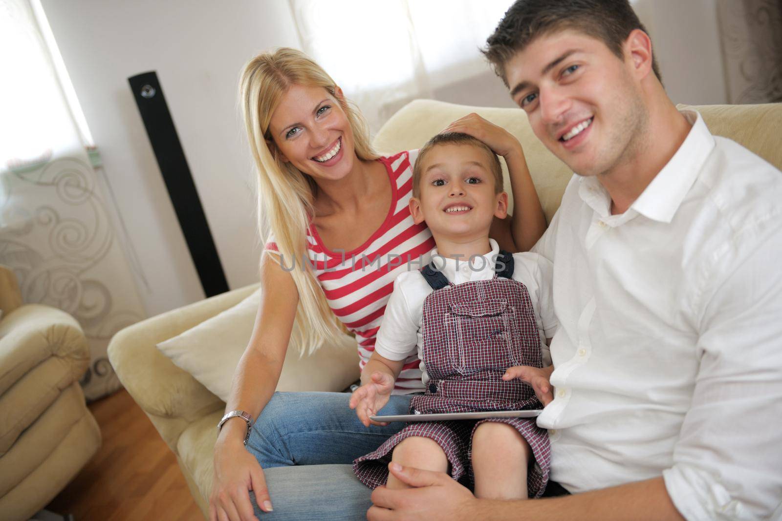 happy young family using tablet computer at modern  home for playing games and education