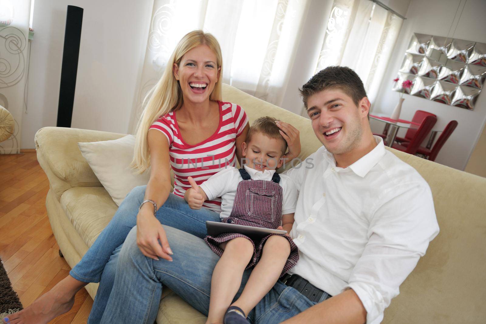 happy young family using tablet computer at modern  home for playing games and education