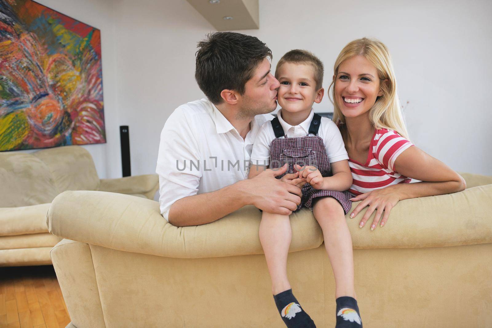 happy young family with kids in bright modern living room have fun and looking big flat lcd tv