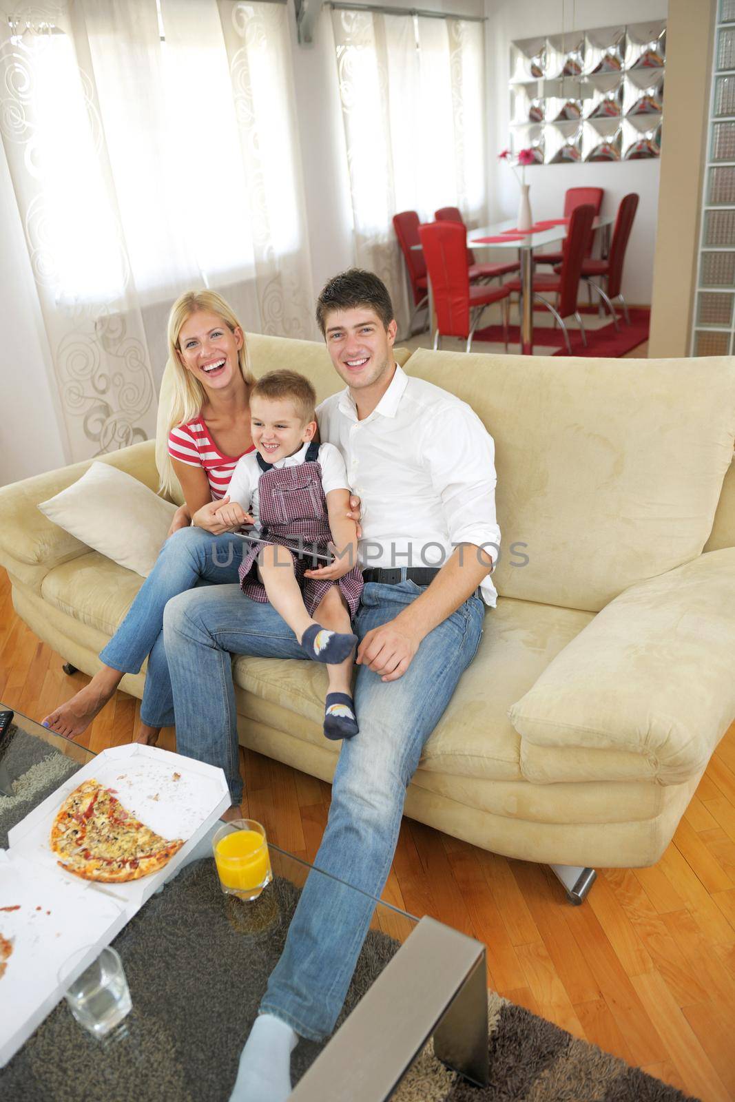 happy young family using tablet computer at modern  home for playing games and education