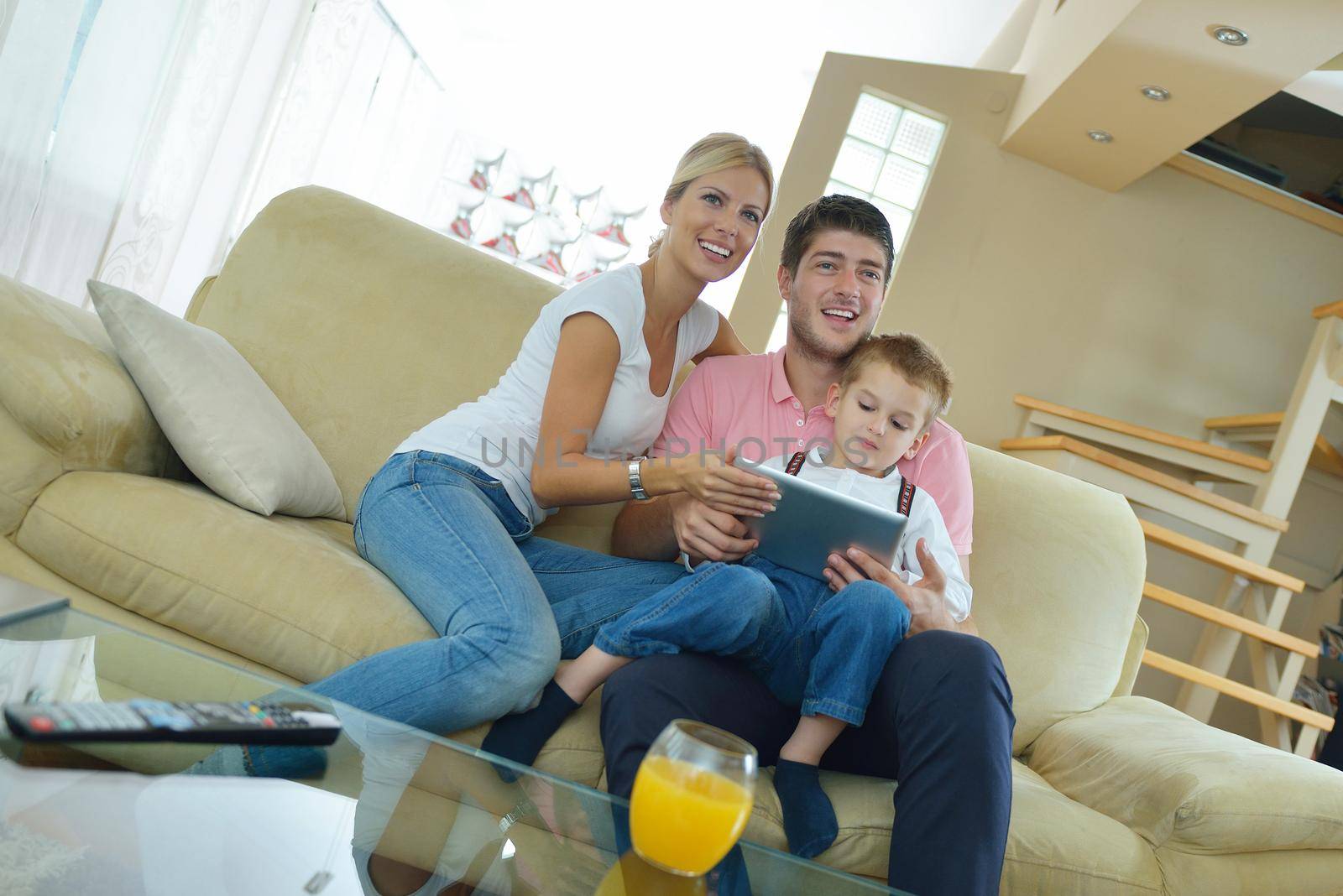 happy young family using tablet computer at modern  home for playing games and education