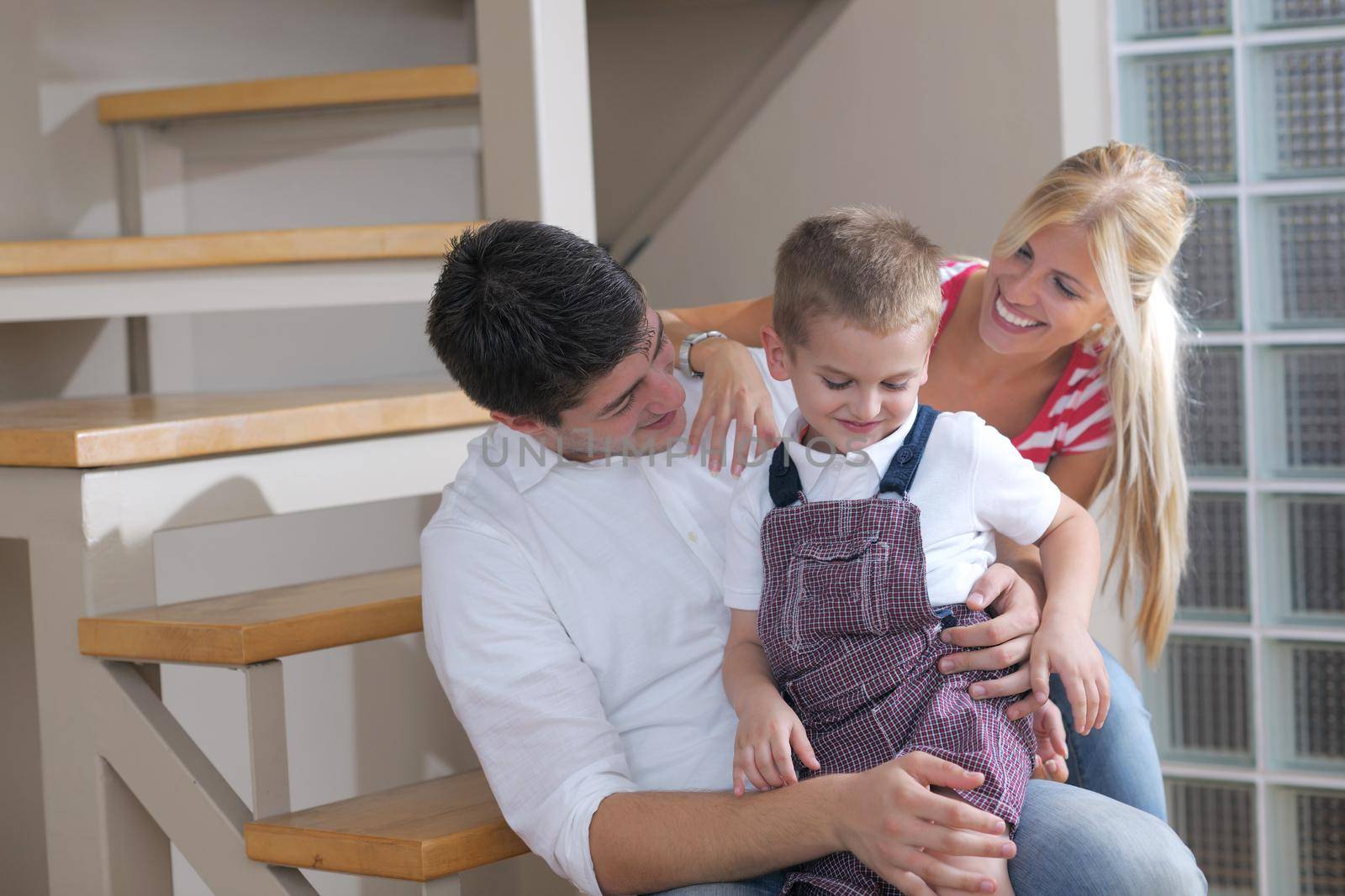 happy young family with kids in bright modern living room have fun and looking big flat lcd tv