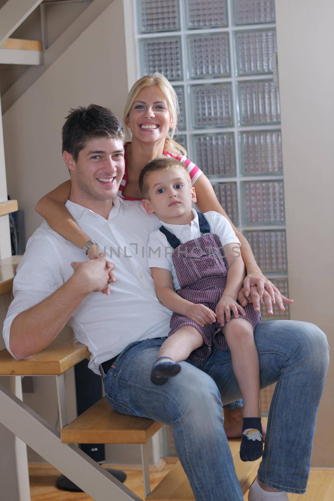 happy young family with kids in bright modern living room have fun and looking big flat lcd tv