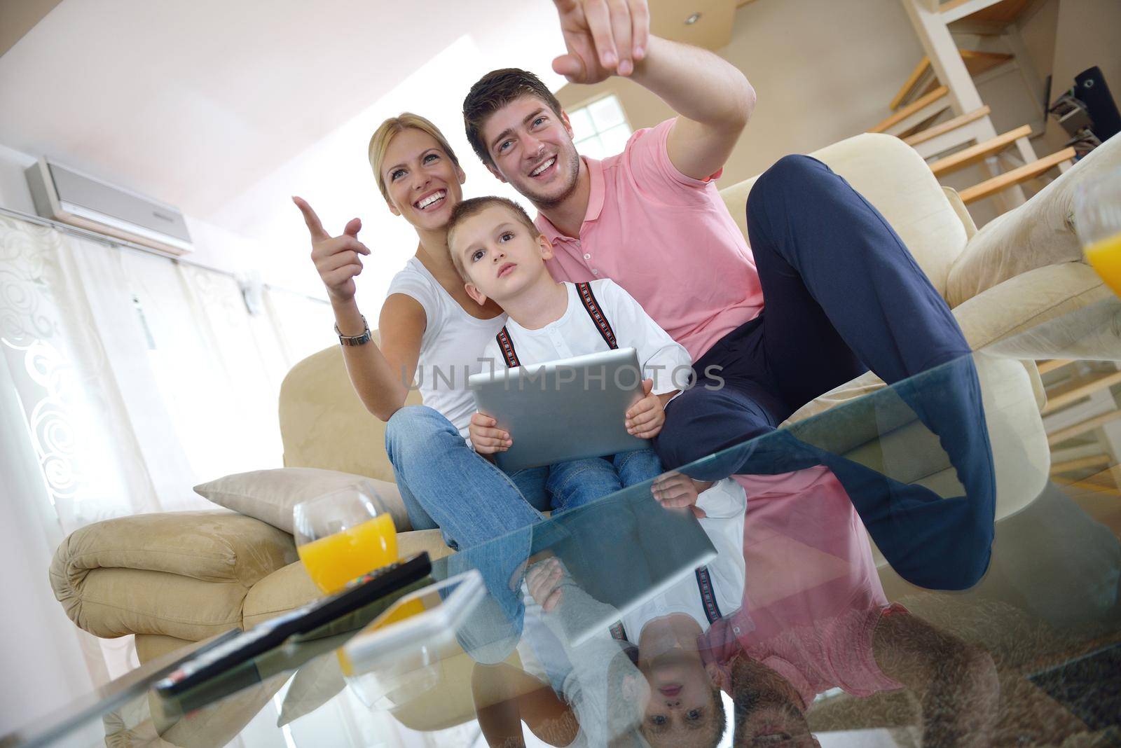 happy young family using tablet computer at modern  home for playing games and education