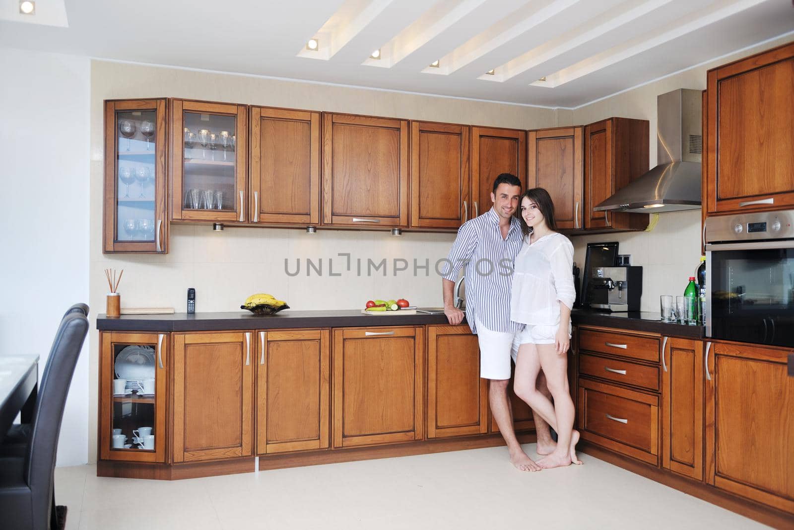 happy young couple have fun in modern kitchen by dotshock