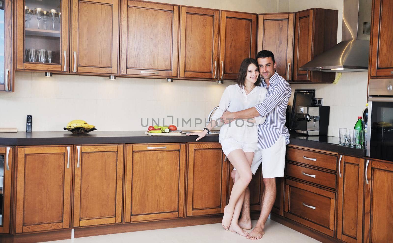 happy young couple have fun in modern kitchen by dotshock