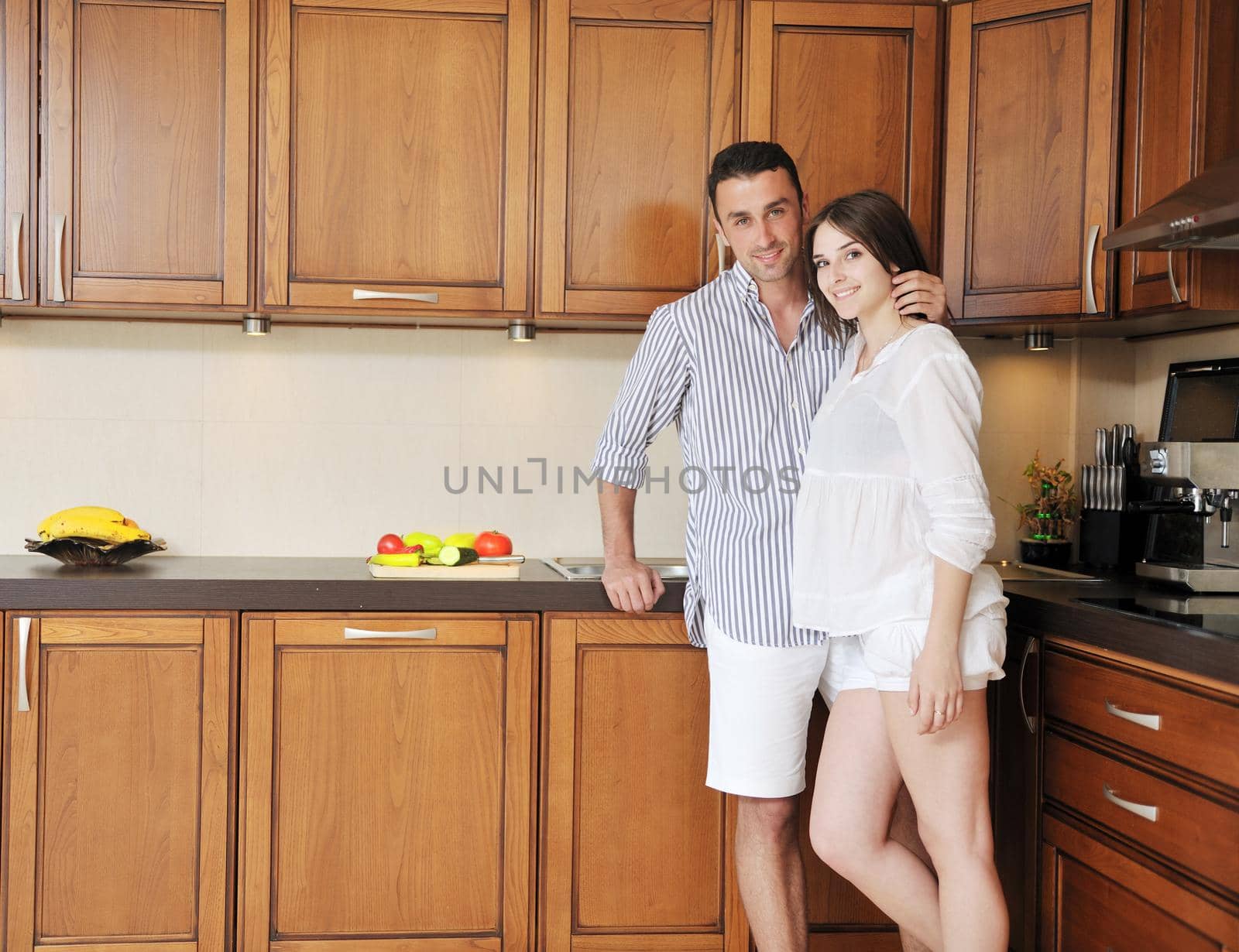 happy young couple have fun in modern kitchen by dotshock