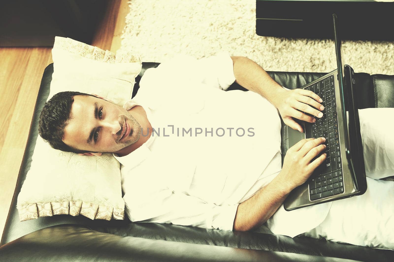 Portrait of a relaxed young guy using laptop at home by dotshock
