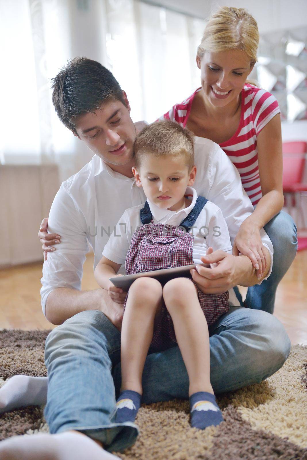 happy young family using tablet computer at modern  home for playing games and education