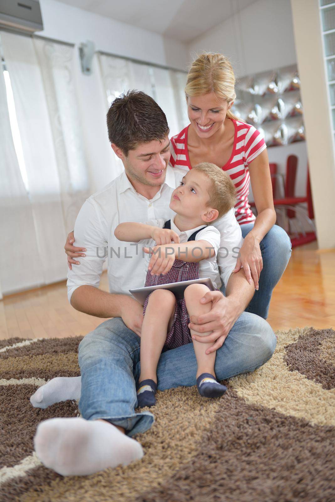 happy young family with kids in bright modern living room have fun and looking big flat lcd tv