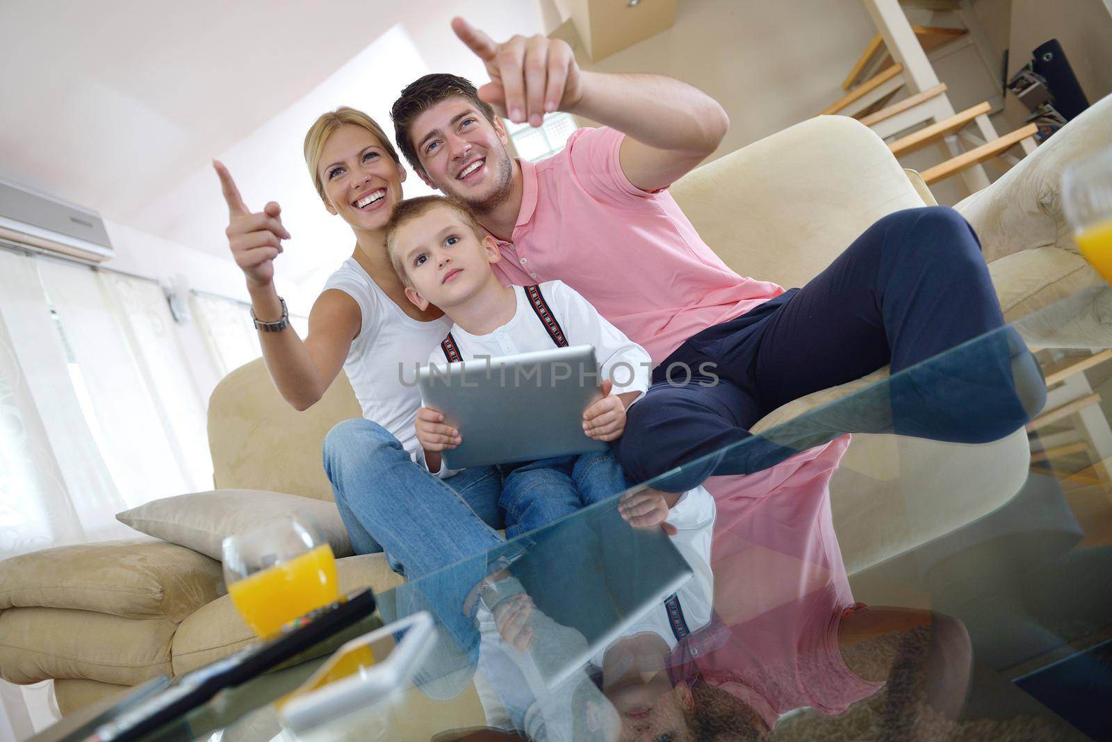 happy young family using tablet computer at modern  home for playing games and education