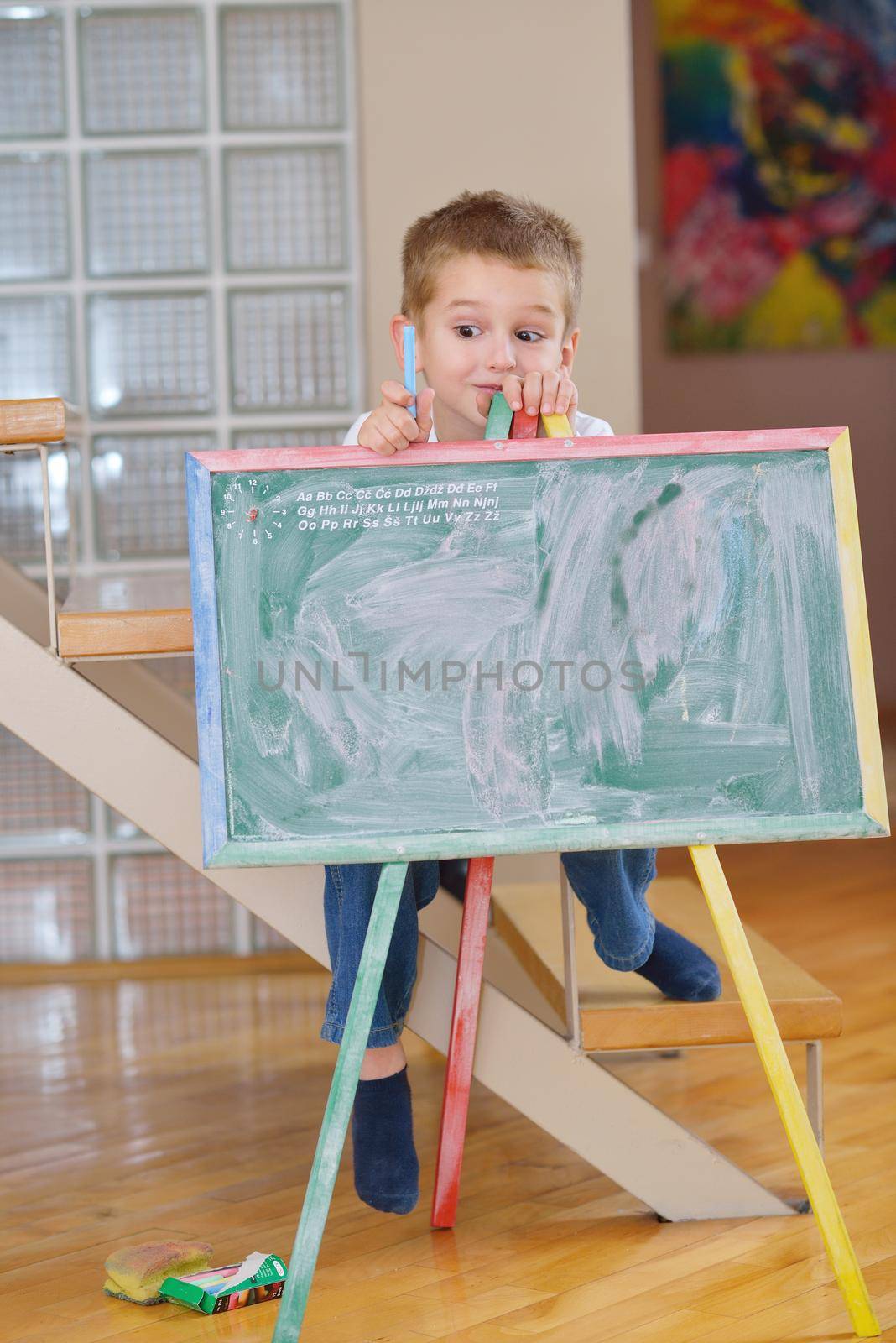 happy young family teach leassons and prepare their son for school while draw on board at home