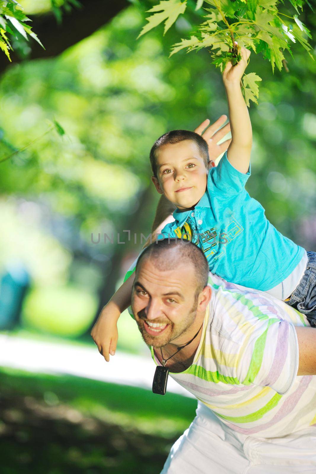 family father and son have fun at park on summer season and representing happines concept