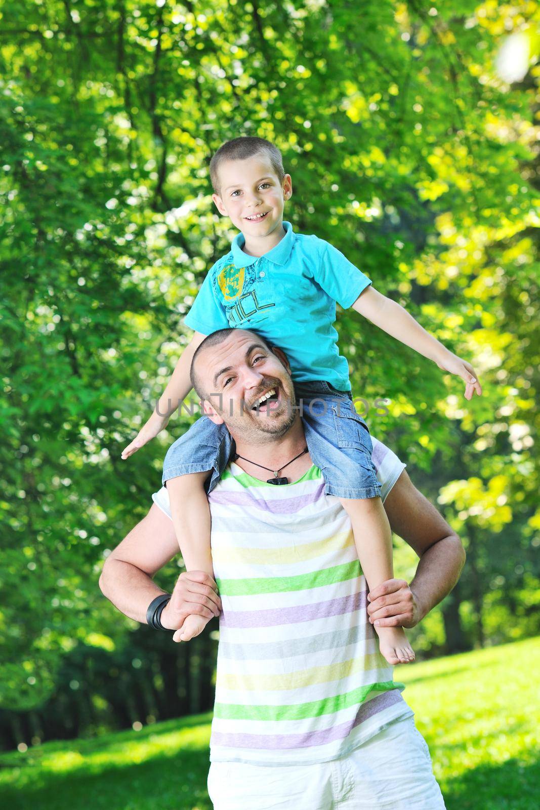 family father and son have fun at park on summer season and representing happines concept