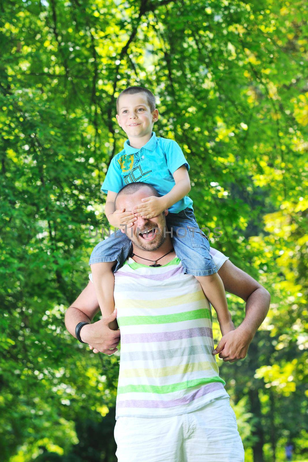 family father and son have fun at park on summer season and representing happines concept