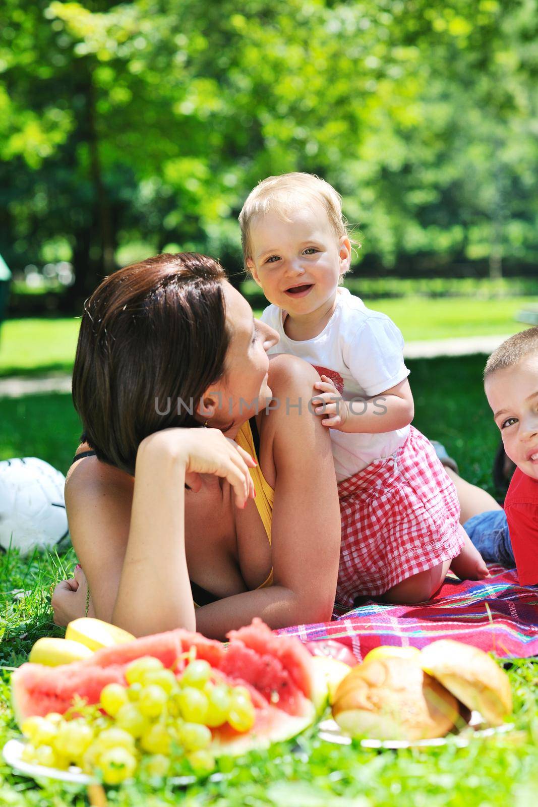 happy young woman and baby have fun while playing in beautiful bright park at summer season