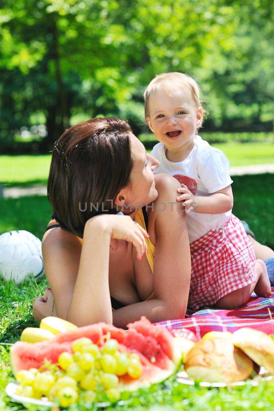 happy young woman and baby have fun while playing in beautiful bright park at summer season