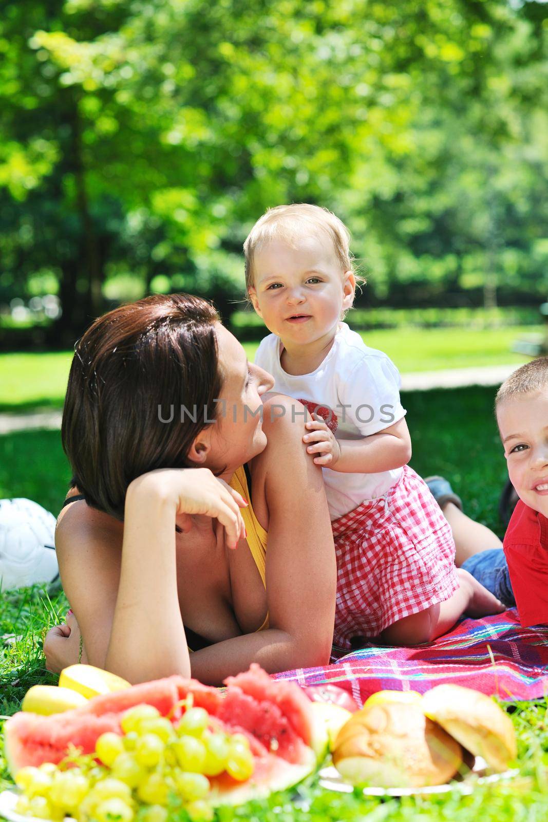 happy young woman and baby have fun while playing in beautiful bright park at summer season