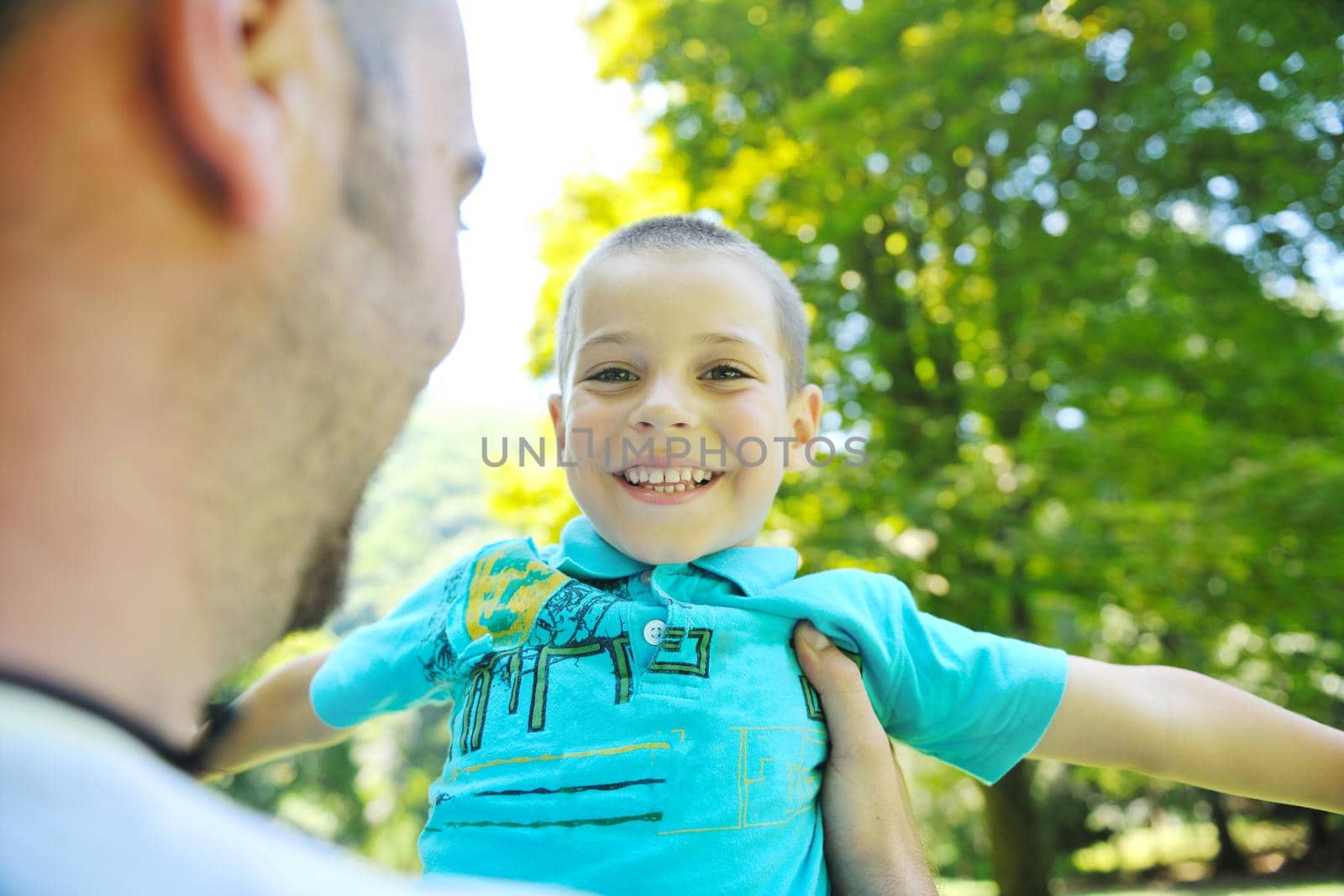 family father and son have fun at park on summer season and representing happines concept