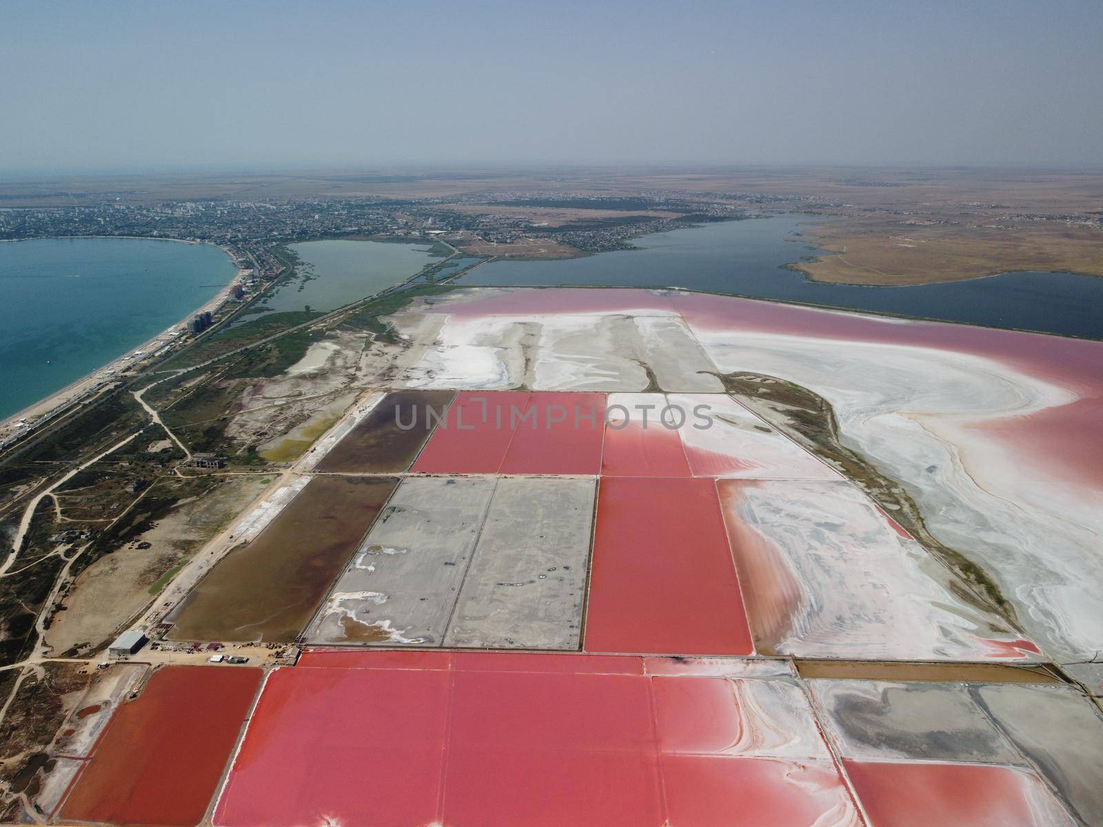 Aerial drone footage of a pink salt lake on a beautiful summer evening. Aerial view of a dried pink salt lake on a beautiful summer evening. Aerial view of a drying out salt lake.