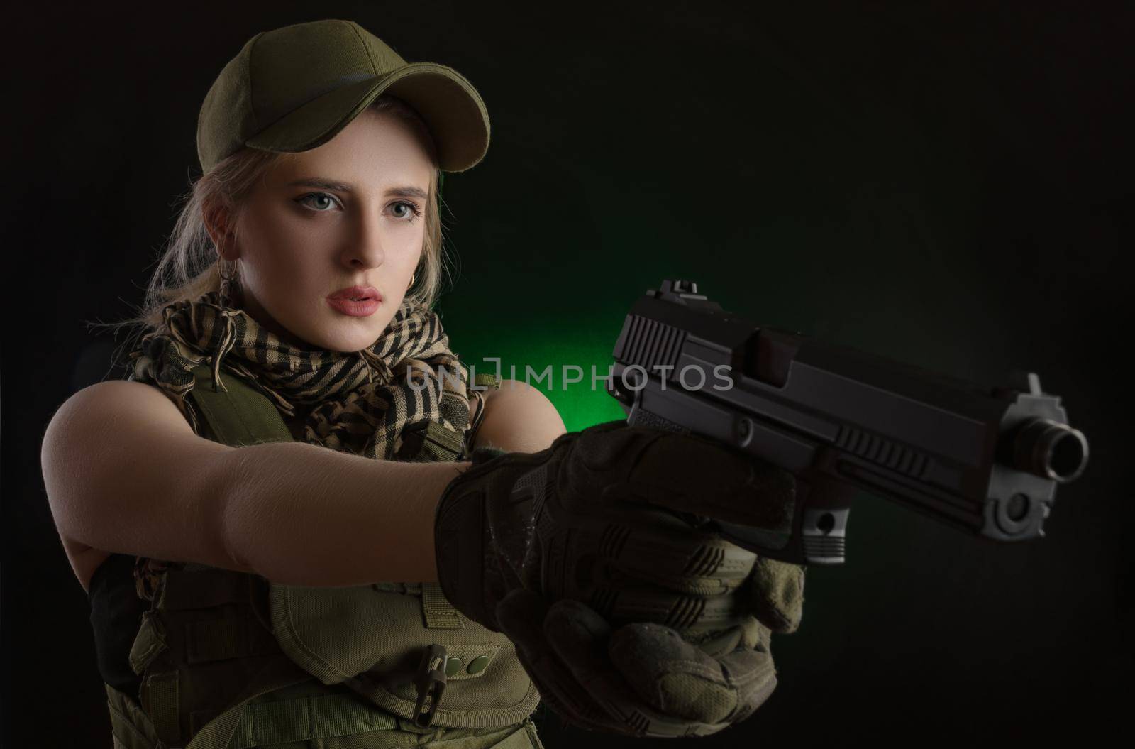 girl in military special clothes posing with a gun in his hands on a dark background in the haze by Rotozey
