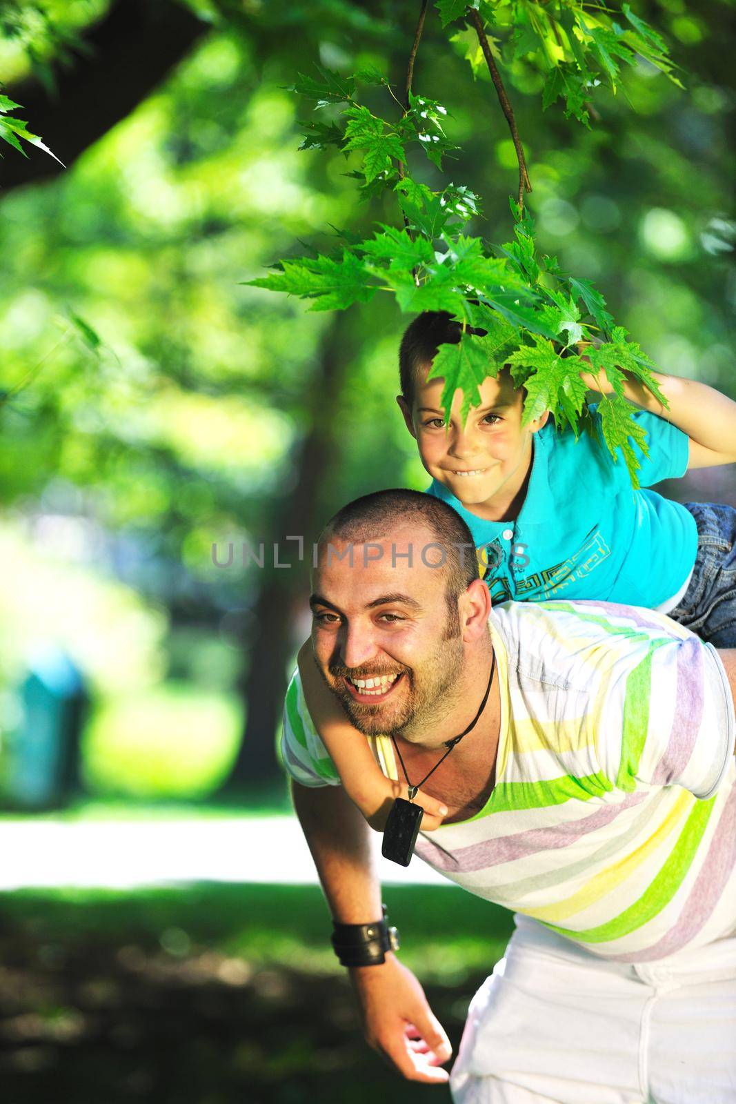 family father and son have fun at park on summer season and representing happines concept