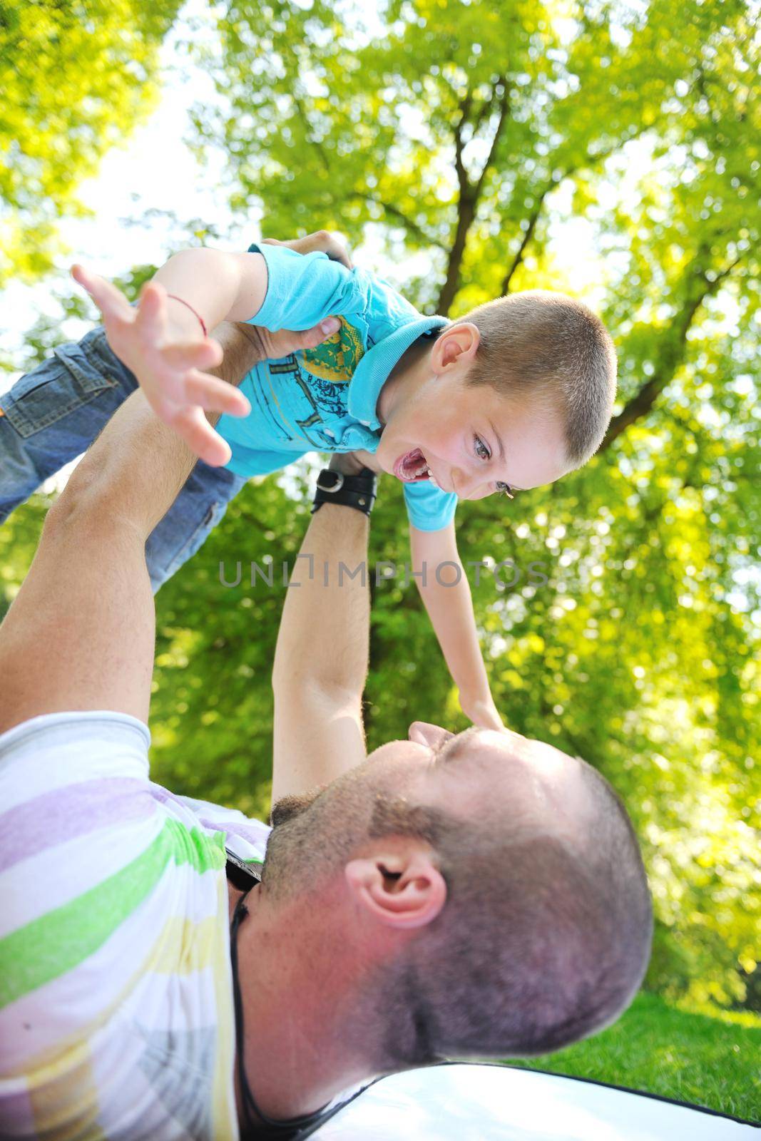 family father and son have fun at park on summer season and representing happines concept