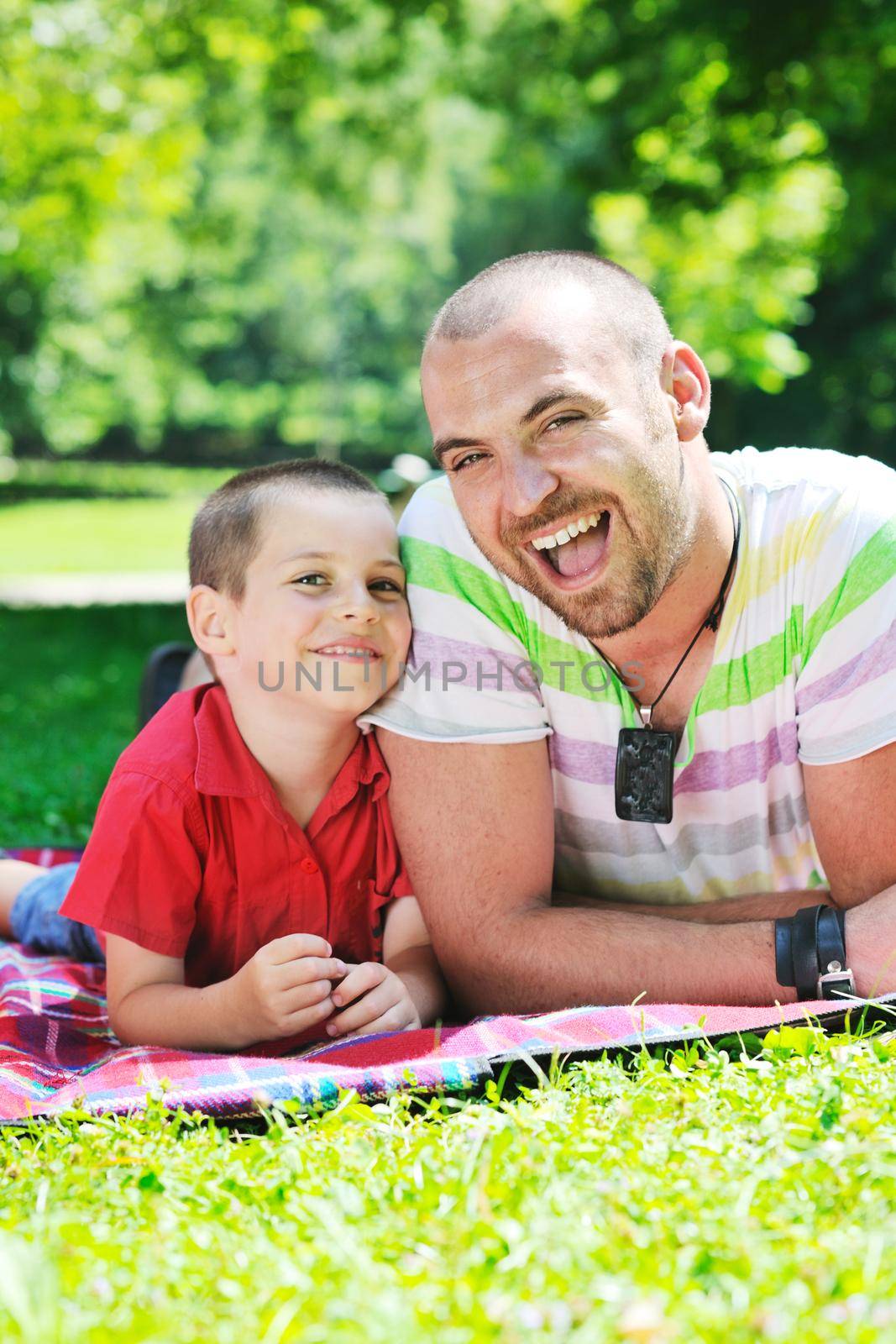 family father and son have fun at park on summer season and representing happines concept