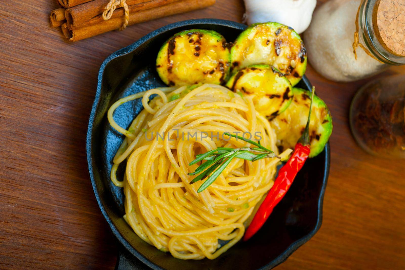 italian spaghetti pasta with zucchini sauce on iron skillet by keko64