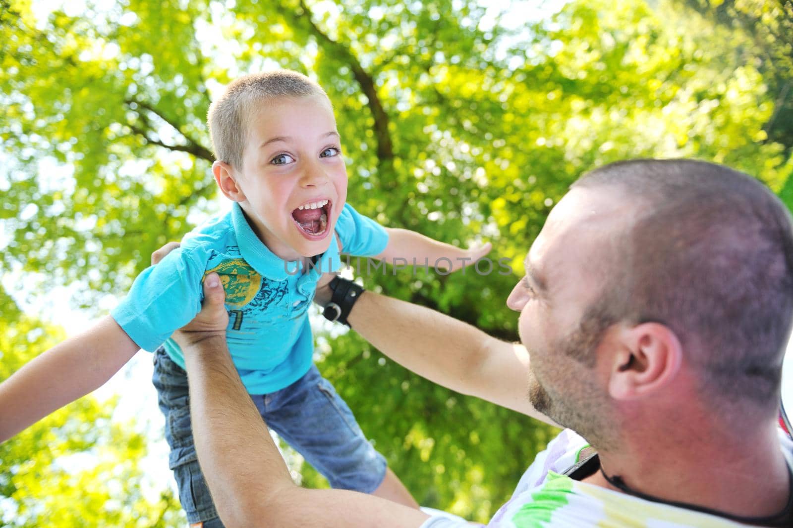 family father and son have fun at park on summer season and representing happines concept