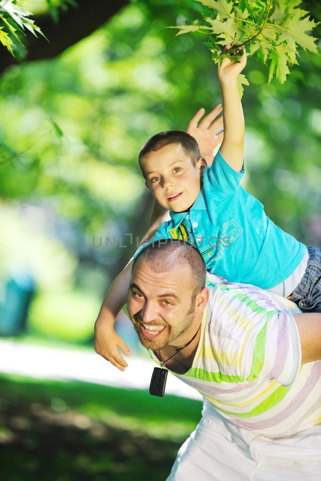 family father and son have fun at park on summer season and representing happines concept