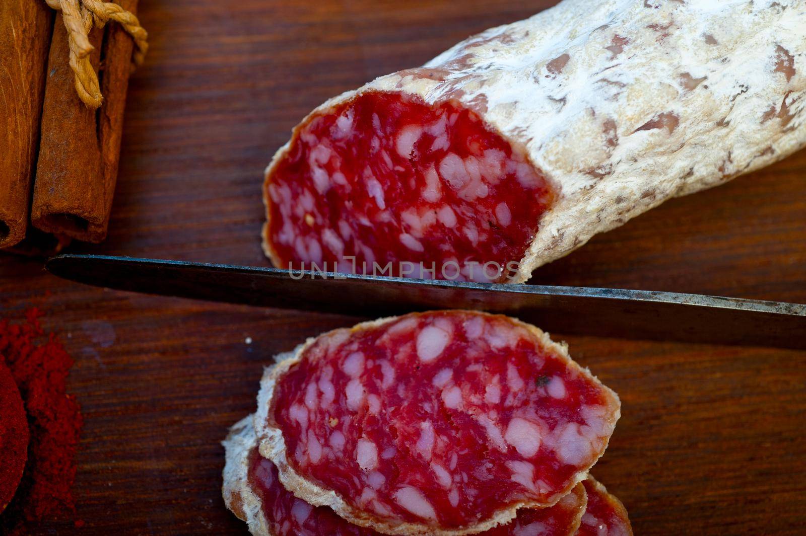 traditional Italian salame cured sausage sliced on a wood board by keko64