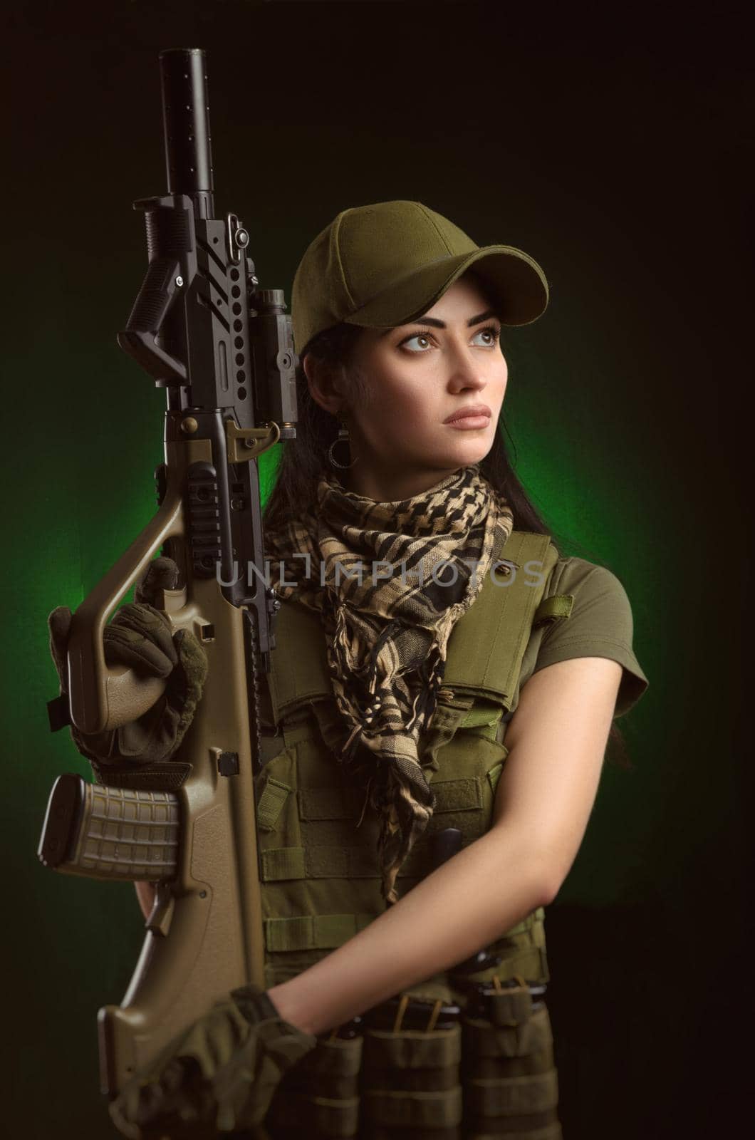 the girl in military special clothes posing with a gun in his hands on a dark background in the haze by Rotozey