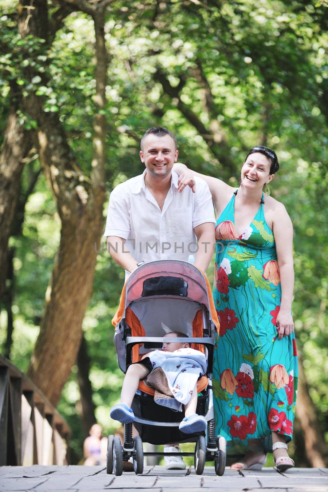 Happy young Family at park relaxing and have fun with pregnant woman