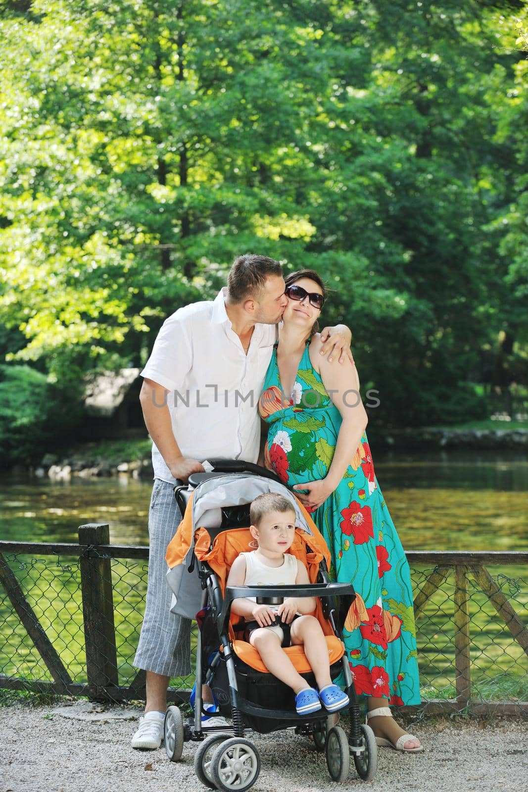 Happy young Family at park relaxing and have fun with pregnant woman