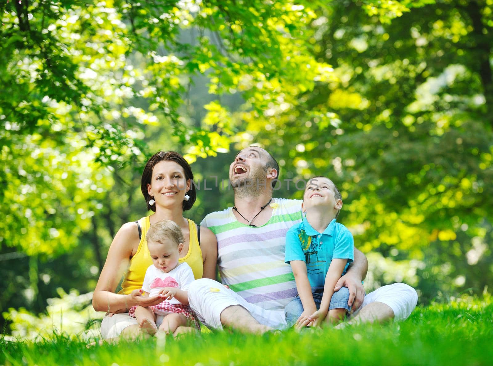 happy young couple with their children have fun at park by dotshock