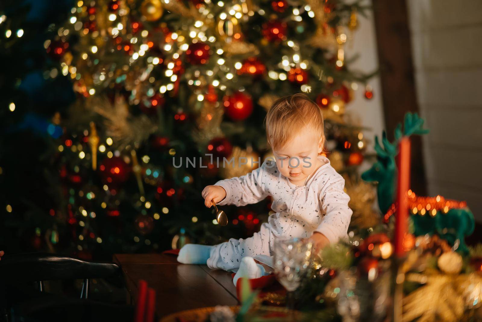 Child celebrating holidays near Christmas tree