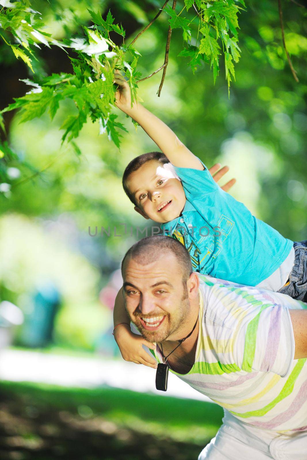 happy father and son have fun at park by dotshock