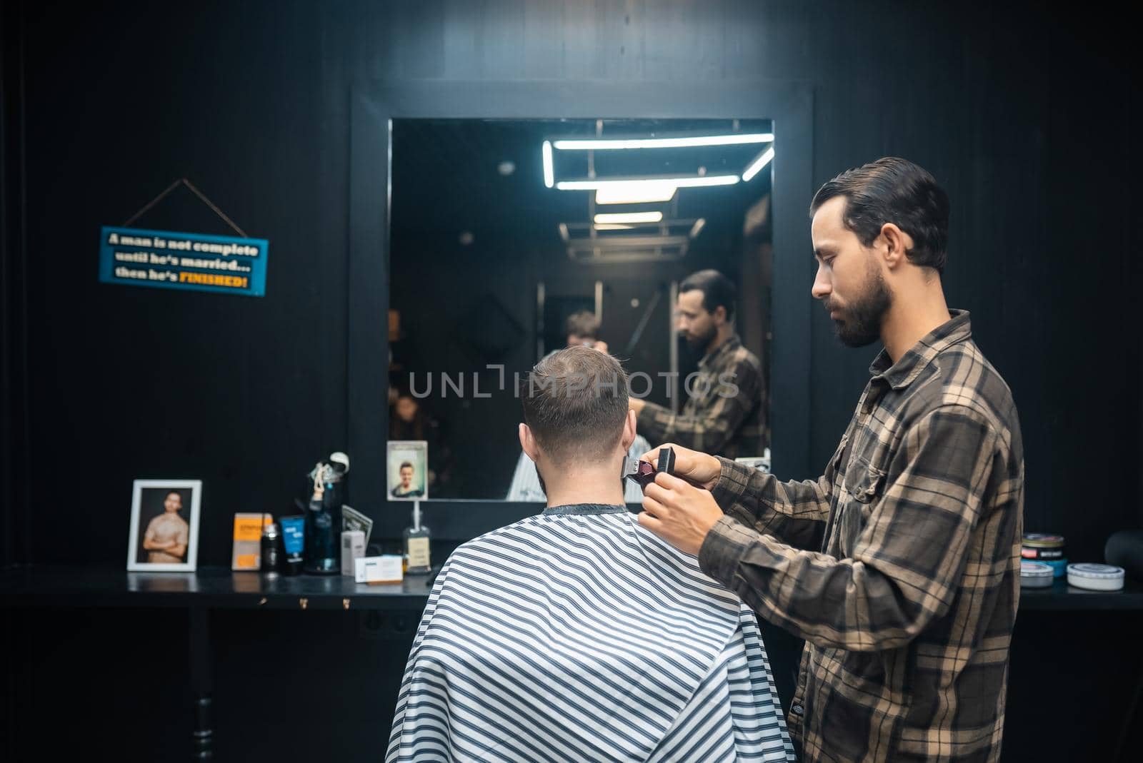 Men's hairstyling and haircutting with hair clipper in a barber shop or hair salon