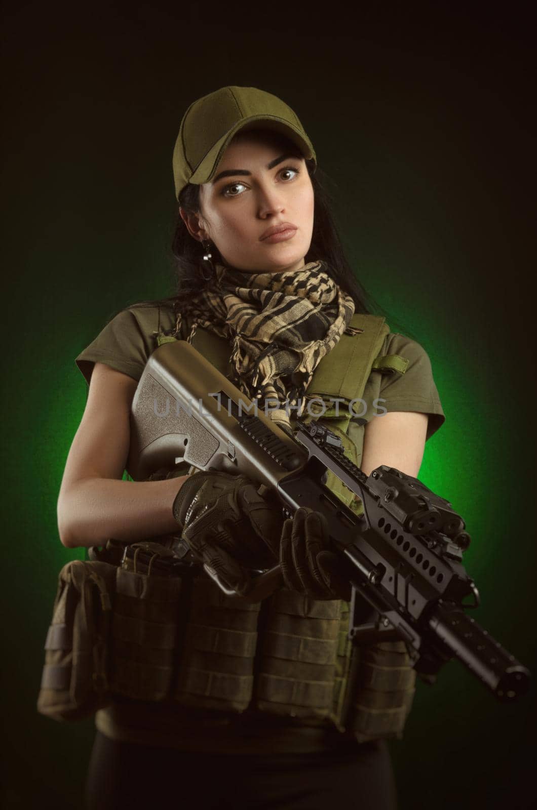 girl in military special clothes posing with a gun in his hands on a dark background in the haze