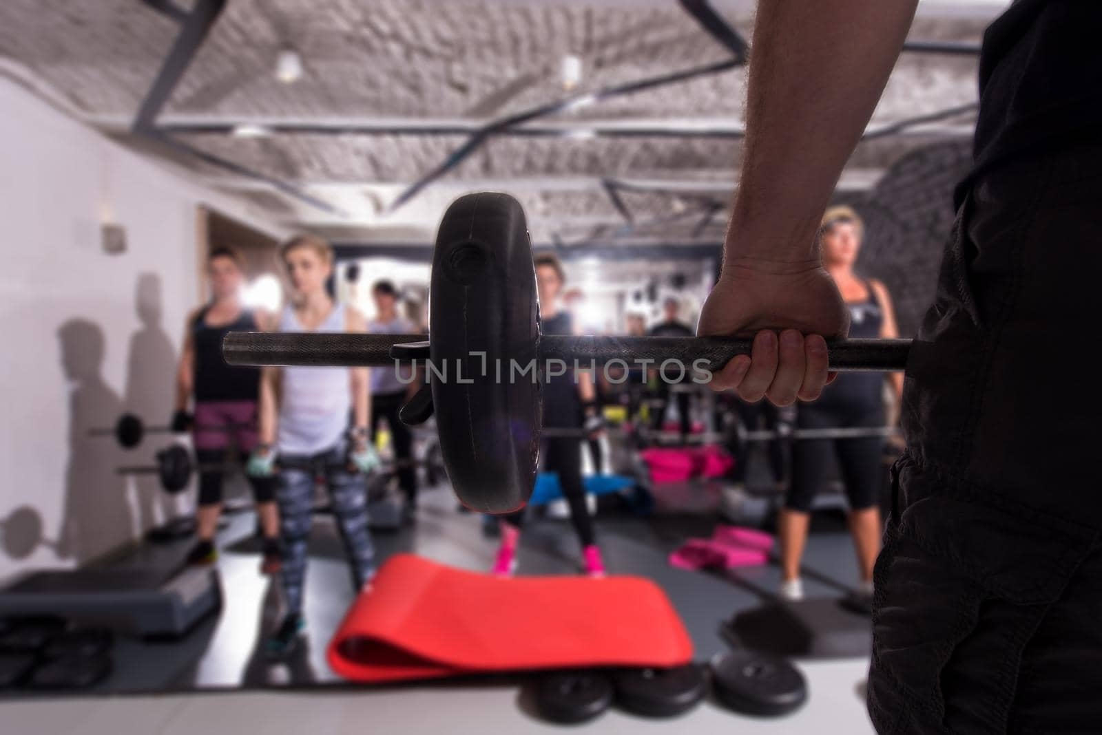 group of young healthy sporty women working out with instructor using barbells while exercises in a fitness studio  fitness, sport, training, gym and lifestyle concept