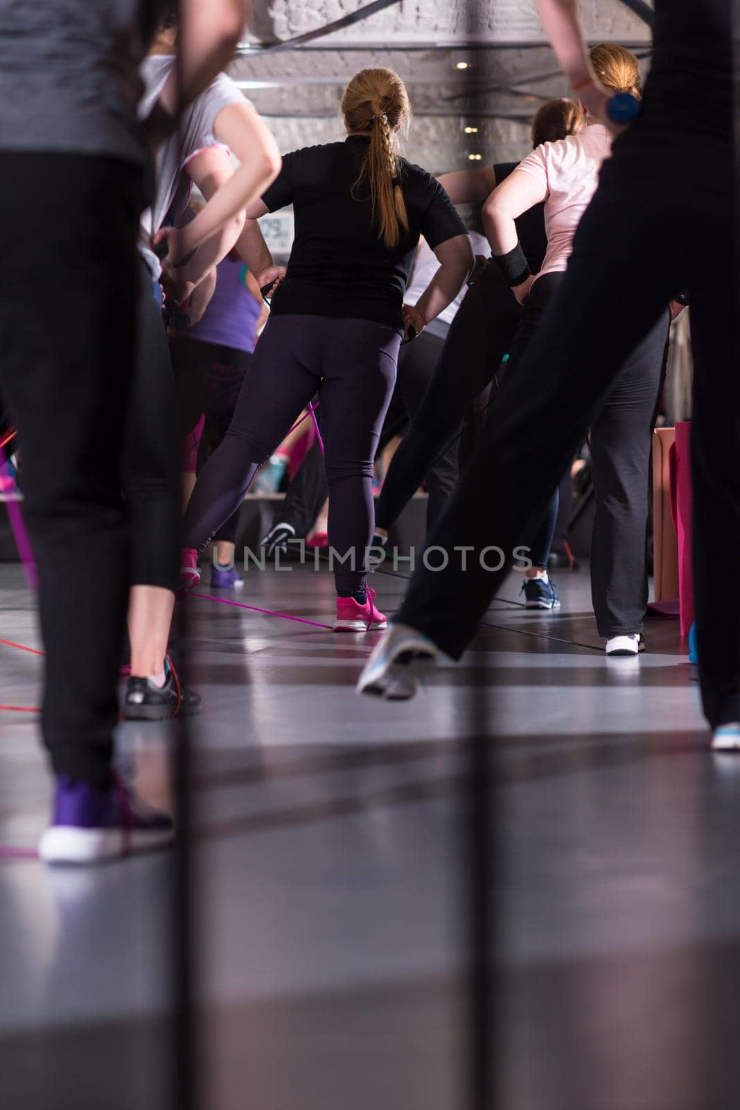 Group of young healthy sporty women exercising with a rubber bands in modern fitness studio  fitness, sport, training, gym and lifestyle concept