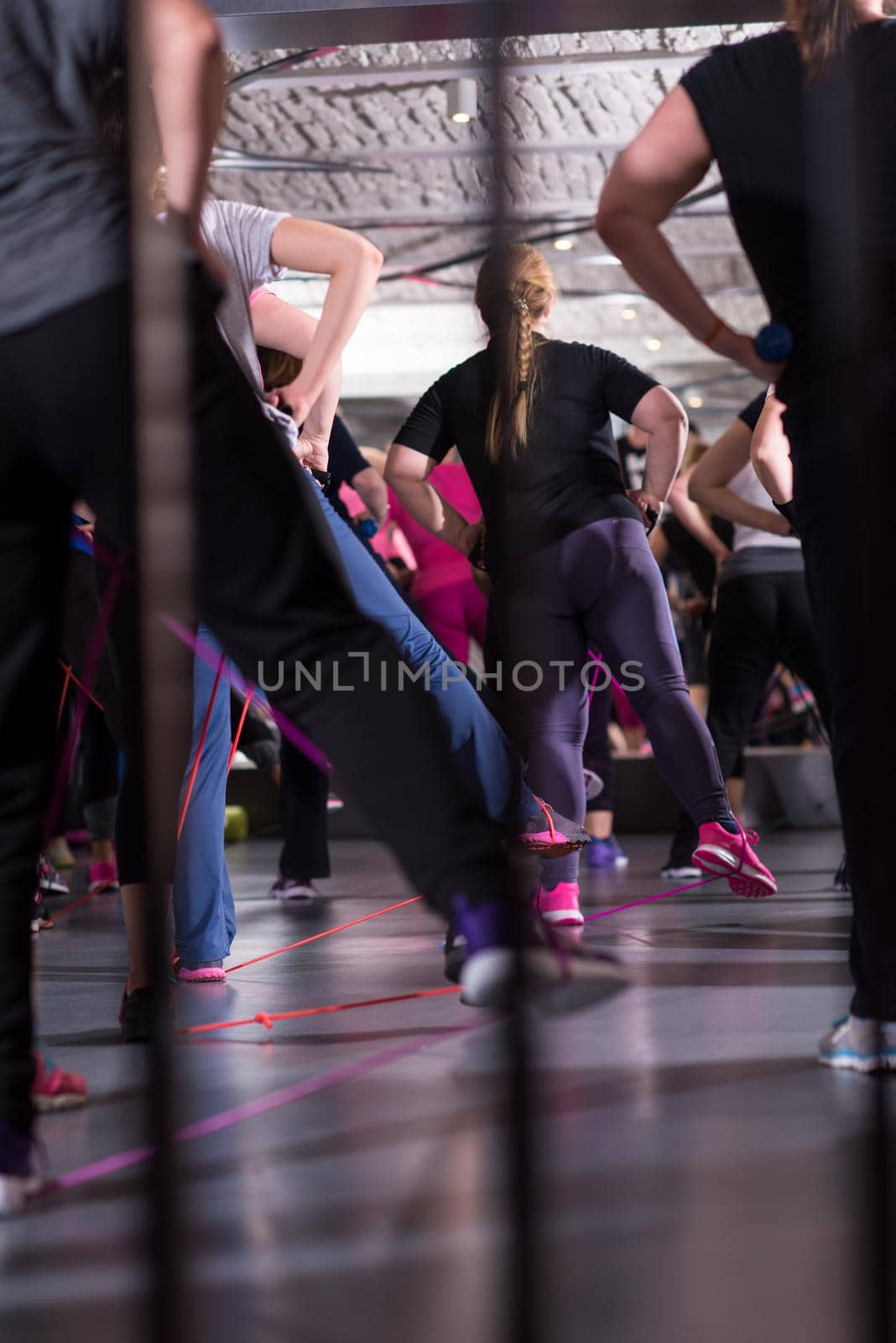 Group of young healthy sporty women exercising with a rubber bands in modern fitness studio  fitness, sport, training, gym and lifestyle concept