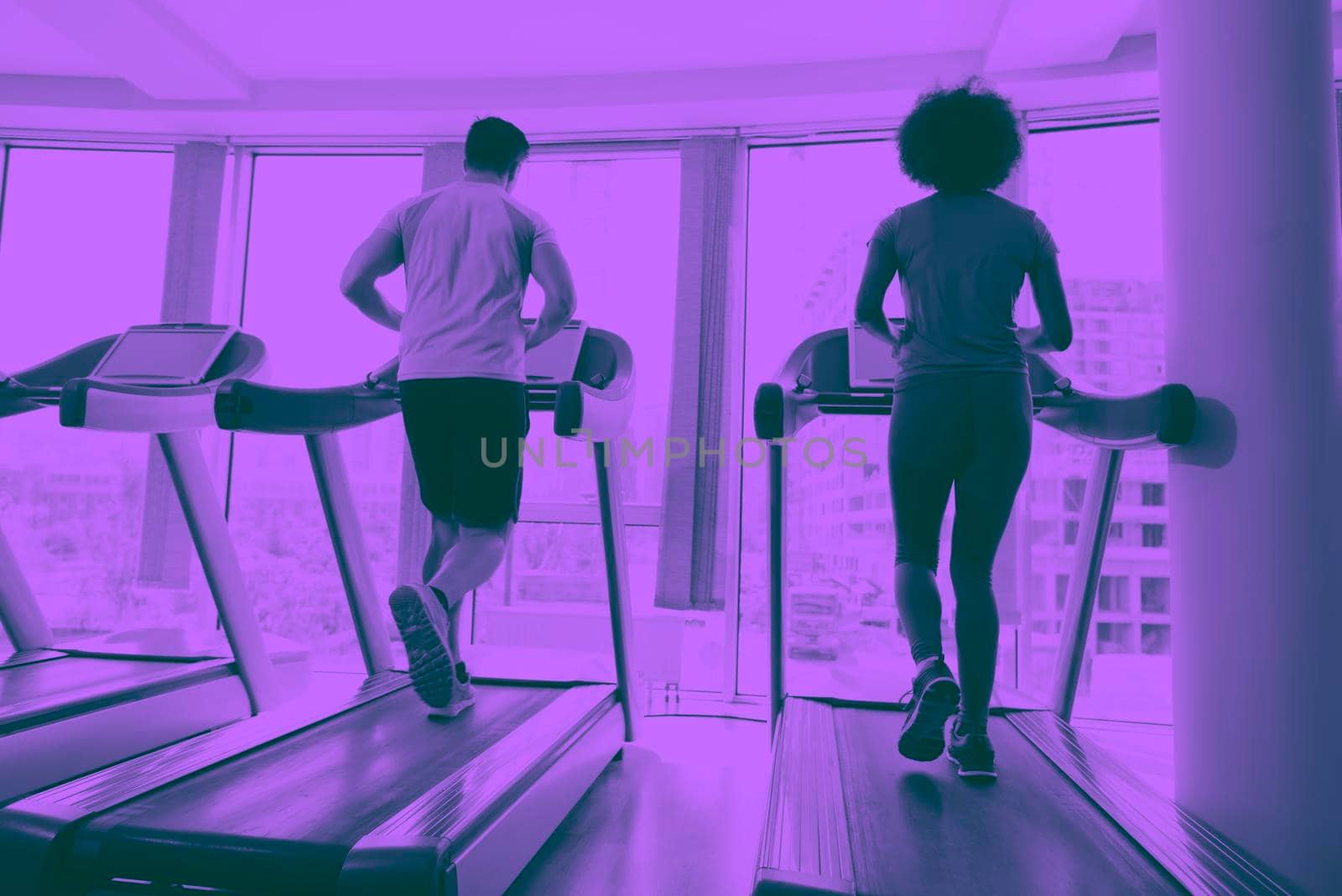 young people exercisinng a cardio on treadmill running chine in modern gym duo tone filter