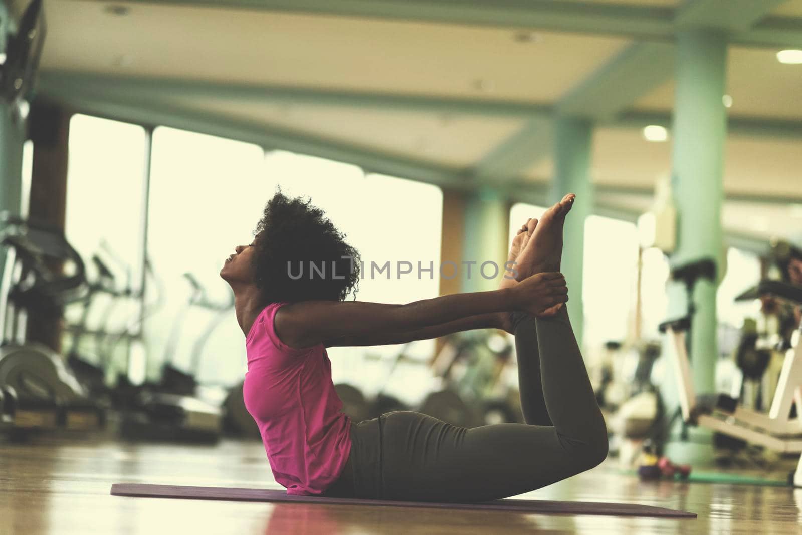 african american woman exercise yoga in gym by dotshock