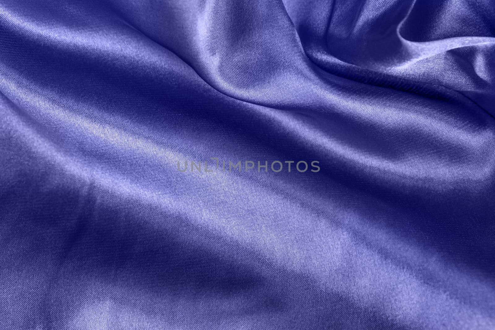 Color of the year 2022 elegant smooth silk or satin folds closeup. Cloth texture background. Abstract wallpaper. Trendy violet backdrop for web design. Luxury twisted fabric backplate