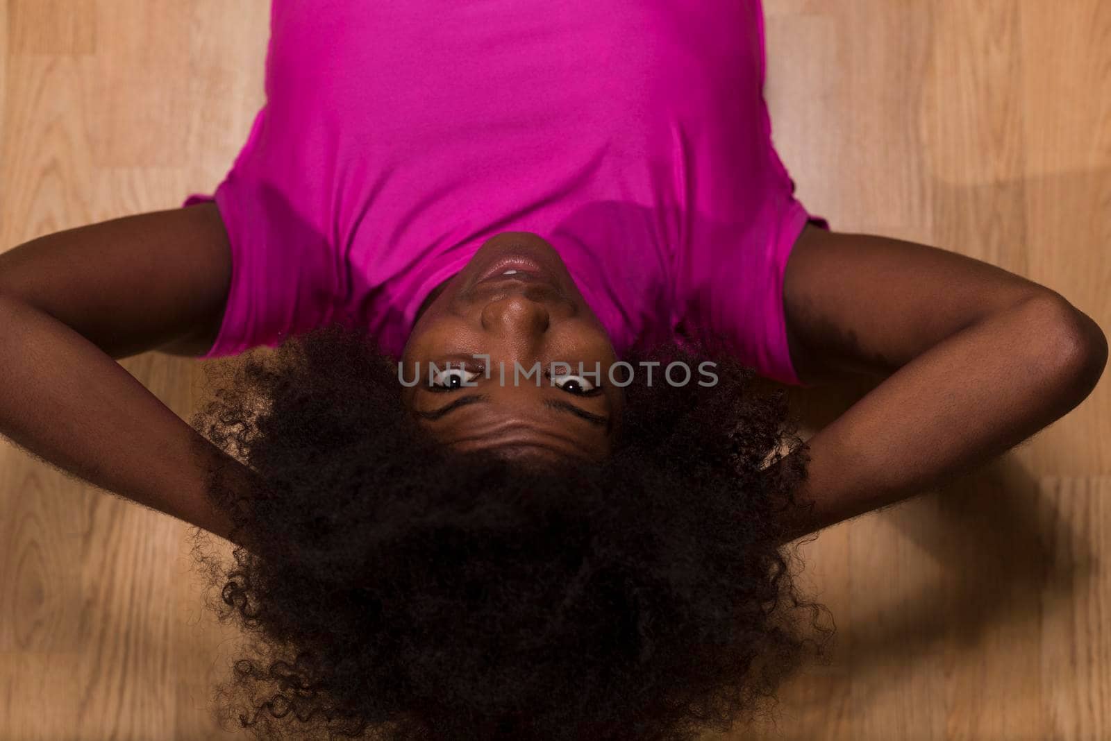 happy african american woman with a curly afro hairstyle in a  gym relaxing after pilates workout